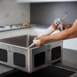 Acid-free silicone adhesive for undermount installation of stainless steel sinks